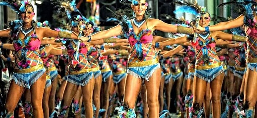 Mujeres con trajes coloridos con plumas presentándose en el Carnaval de Sitges
