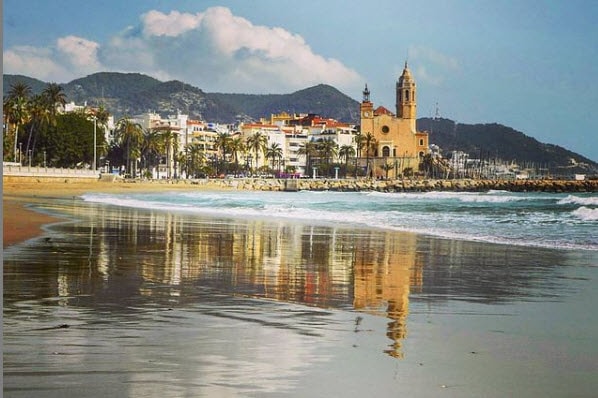 Reflejo de Sitges en el agua de la playa