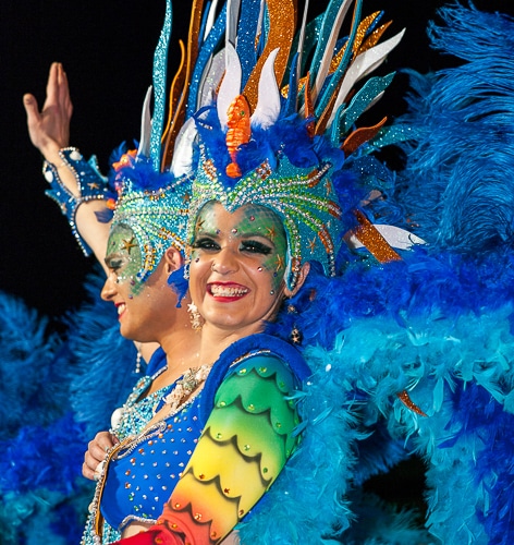 Una bailarina sonriendo con un colorido disfraz en el Carnaval de Sitges