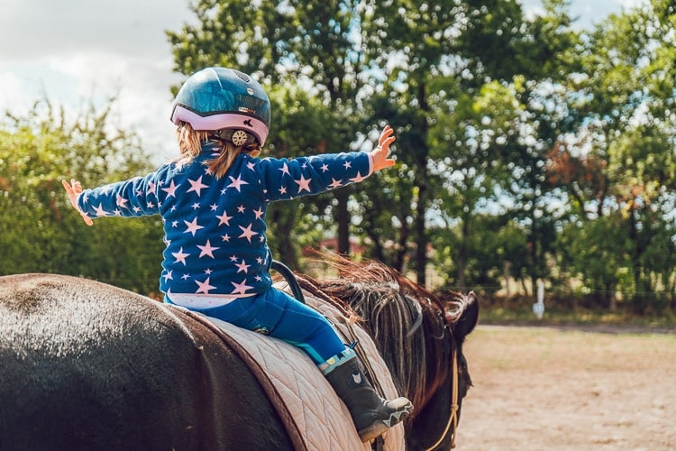 Niña feliz en un paseo en poni