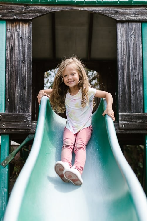 Niña sonriendo en un tobogán 