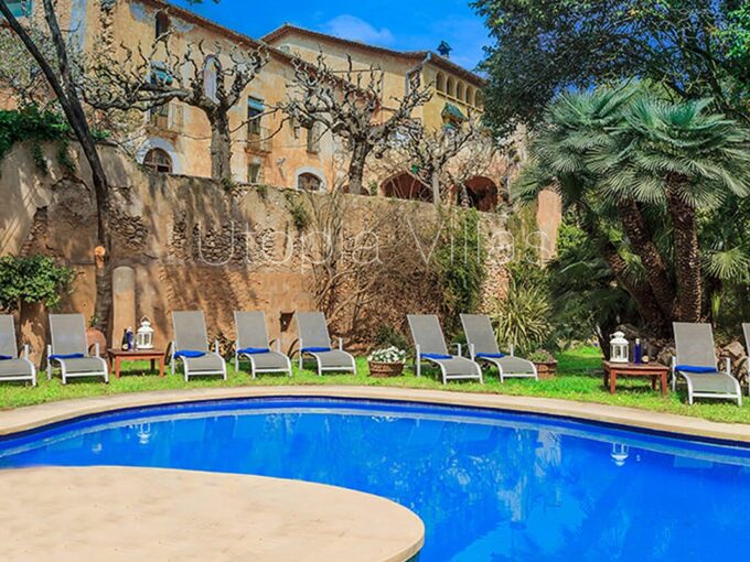 Villa Catalina bajo el sol en una toma de su fachada y preciosa piscina, Sitges, Barcelona