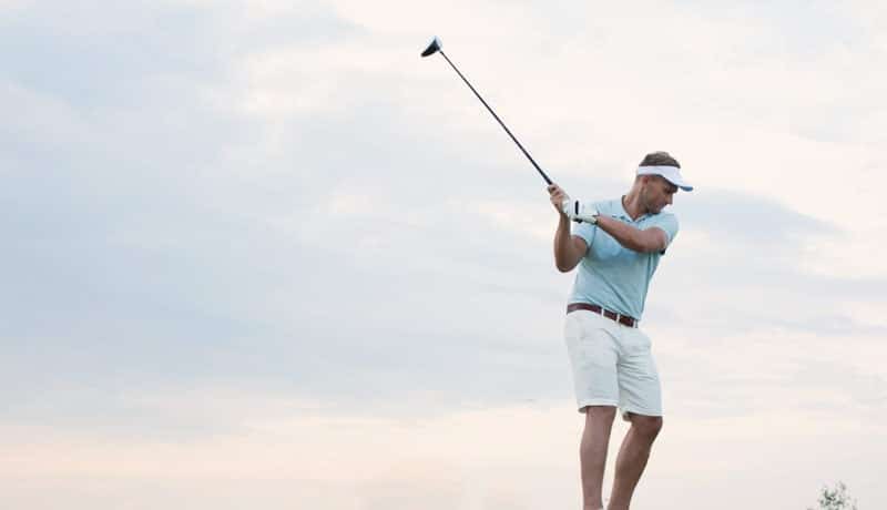 Mid-adult man playing golf against sky