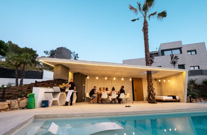 Huéspedes cenando al aire libre junto a la piscina en Villa Malena