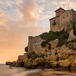 Castle of Tamarit on the rocks surrounded by the sea during the sunset in Altafulla in Spain