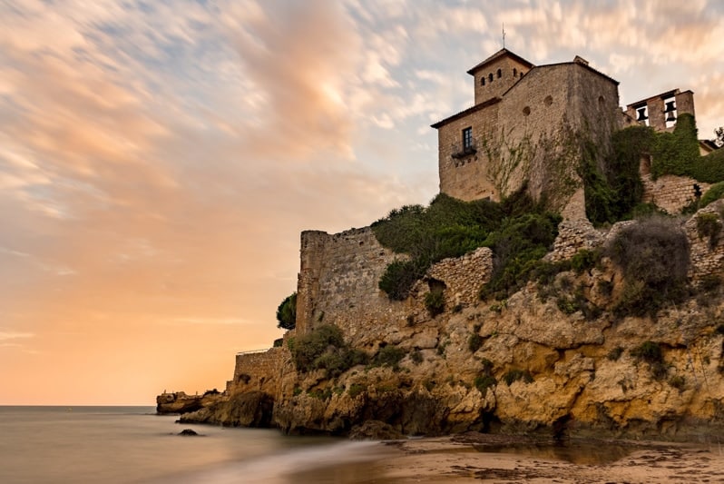 Castle of Tamarit on the rocks surrounded by the sea during the sunset in Altafulla in Spain