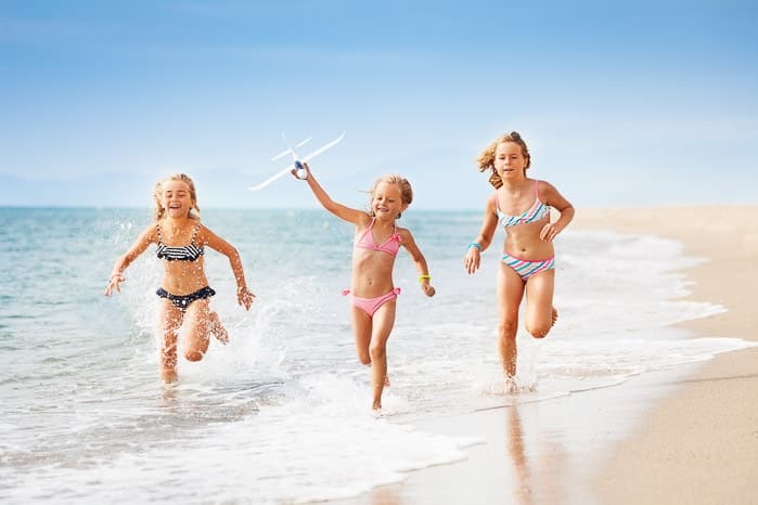 Tres niños que corren en la playa de Sitges