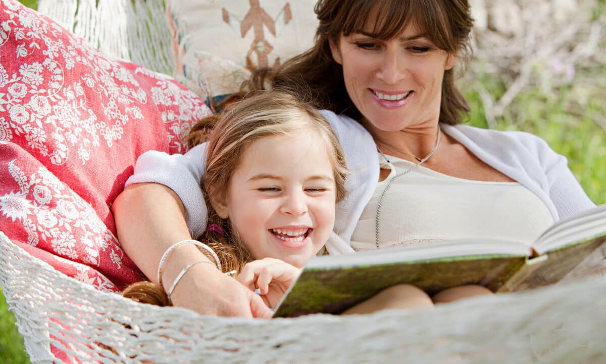 A lady and her daughter relaxing and reading in a Utopia Villa