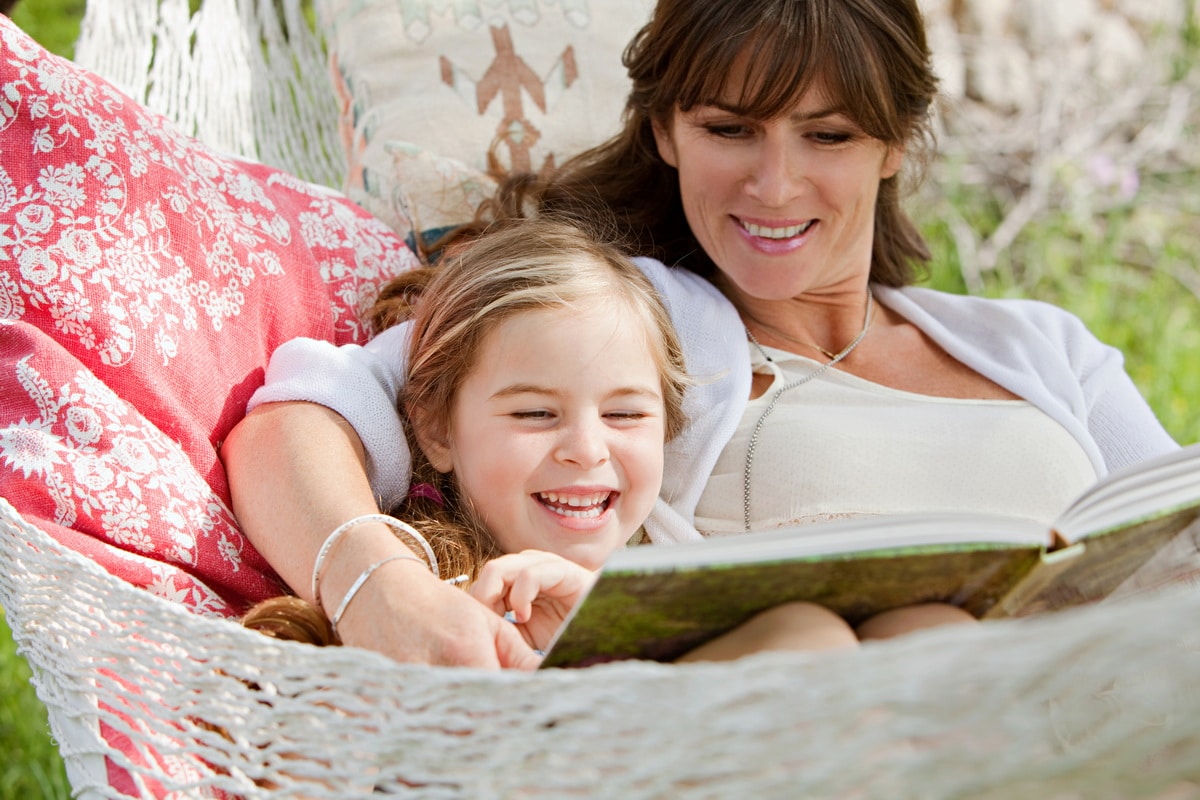 A lady and her daughter relaxing and reading in a Utopia Villa